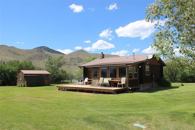 rear view of house with a lawn and a deck with mountain view