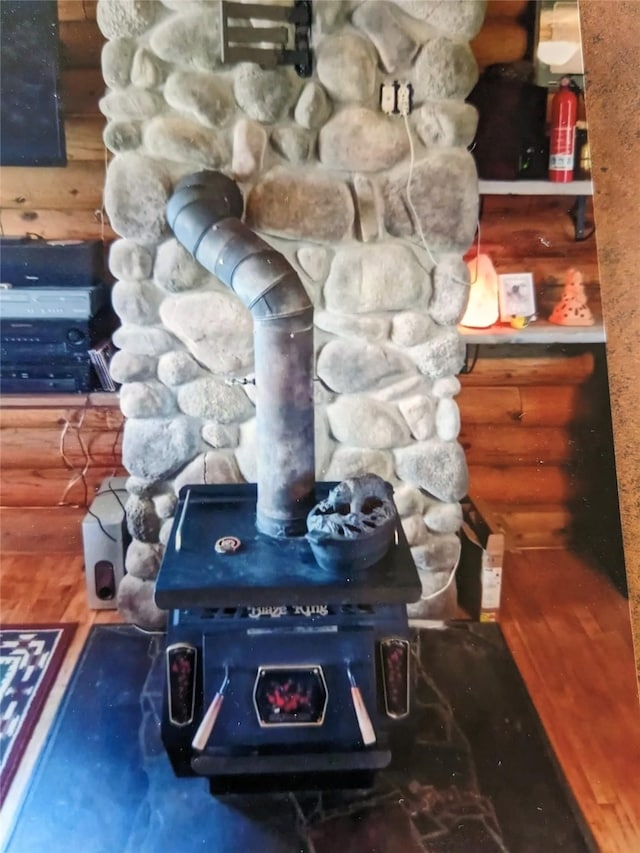 240 Ponderosa Rd, Melrose, MT 59743 - detailed view of log walls, a wood stove, a fire extinguisher, and wood finished floors