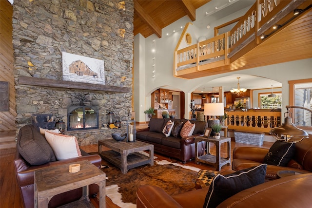 417 Sirucek Ln, Kalispell, MT 59901 - living area featuring hardwood / wood-style floors, a chandelier, a wooden ceiling with exposed beams, a fireplace, and high vaulted ceiling