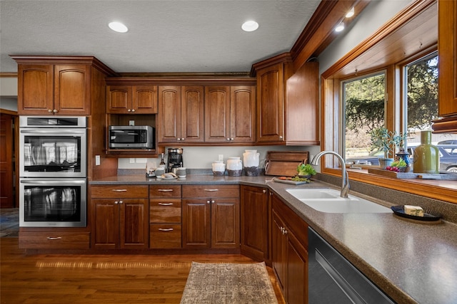 417 Sirucek Ln, Kalispell, MT 59901 - kitchen featuring stainless steel appliances, dark wood-style flooring, dark countertops, a textured ceiling, and brown cabinets