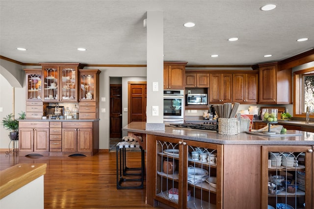 417 Sirucek Ln, Kalispell, MT 59901 - kitchen featuring stainless steel appliances, arched walkways, crown molding, dark wood-style floors, and recessed lighting