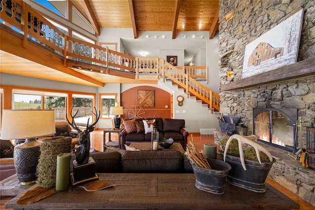 417 Sirucek Ln, Kalispell, MT 59901 - living area featuring a high ceiling, wood finished floors, a fireplace, a wood ceiling with exposed beams, and stairway