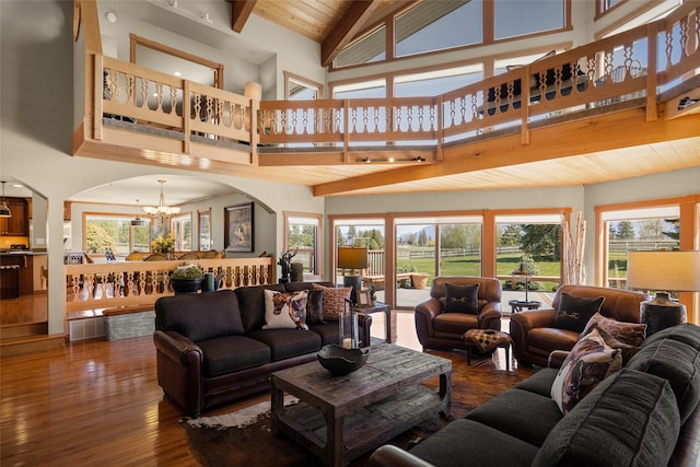 417 Sirucek Ln, Kalispell, MT 59901 - living room featuring high vaulted ceiling, a chandelier, arched walkways, beam ceiling, and wood finished floors