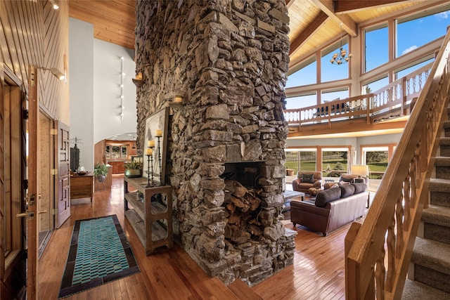 417 Sirucek Ln, Kalispell, MT 59901 - living room featuring high vaulted ceiling, a wooden ceiling with exposed beams, stairs, hardwood / wood-style floors, and arched walkways
