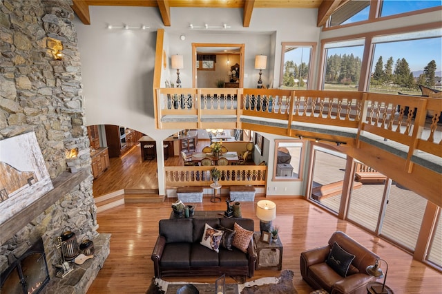 417 Sirucek Ln, Kalispell, MT 59901 - living area with wood finished floors, beamed ceiling, and a stone fireplace