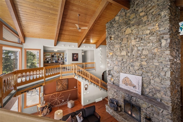417 Sirucek Ln, Kalispell, MT 59901 - living area featuring wood finished floors, ceiling fan, a stone fireplace, and a wood ceiling with exposed beams