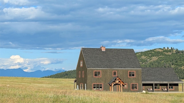 285 N Hill Rd, Kalispell, MT 59901 - view of front of home with a mountain view, roof with shingles, and a chimney