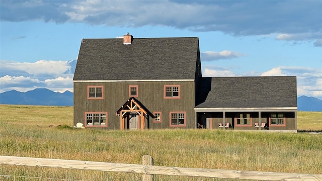 285 N Hill Rd, Kalispell, MT 59901 - view of front of property with a chimney, a mountain view, and a shingled roof
