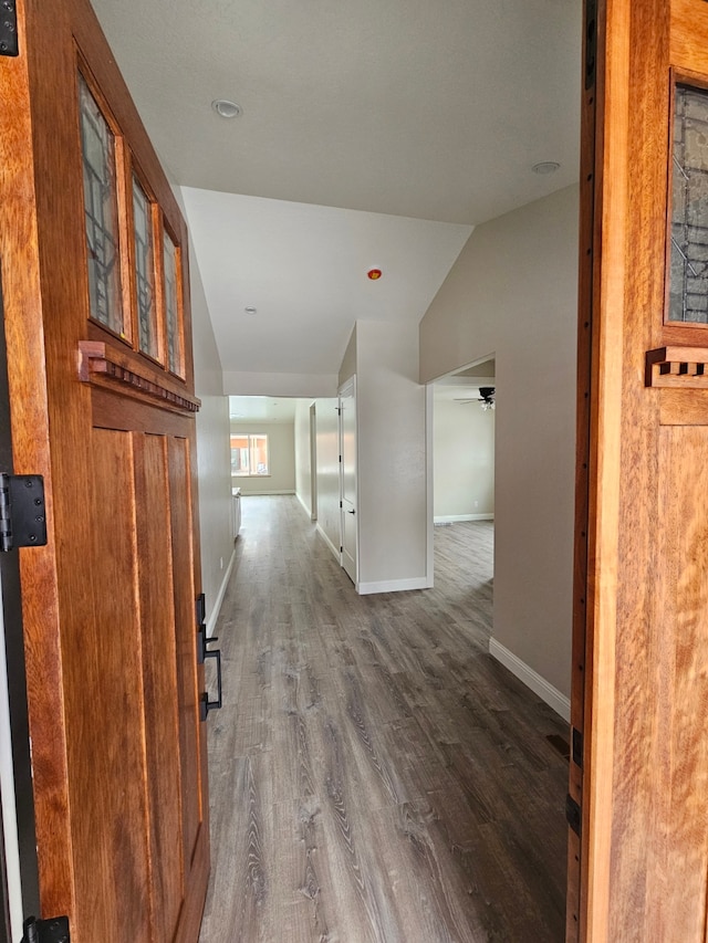 hallway with lofted ceiling and hardwood / wood-style floors