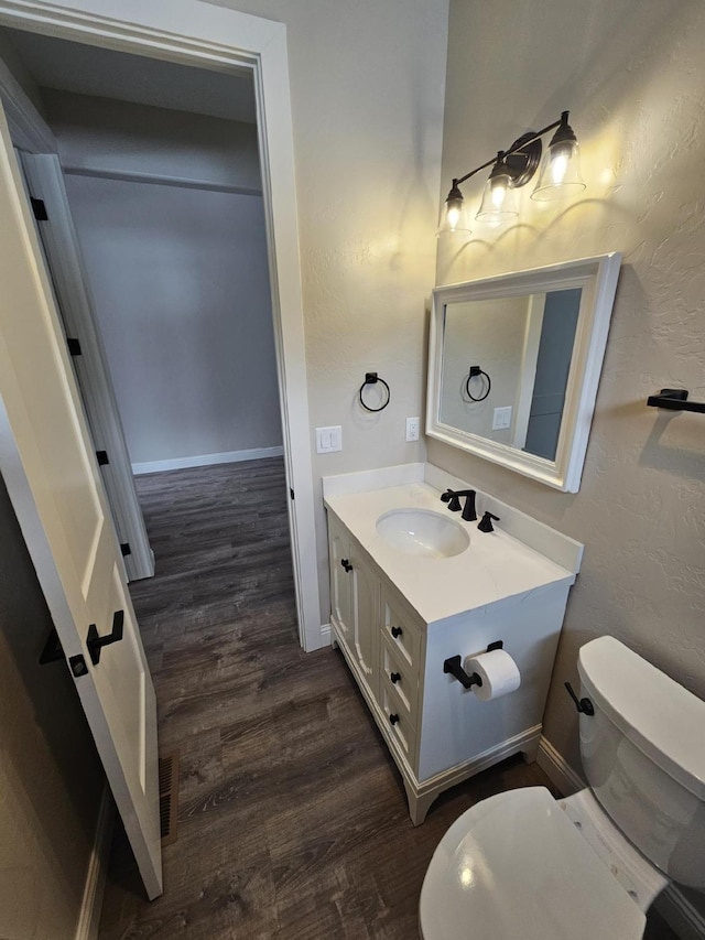 bathroom featuring vanity, toilet, and hardwood / wood-style floors