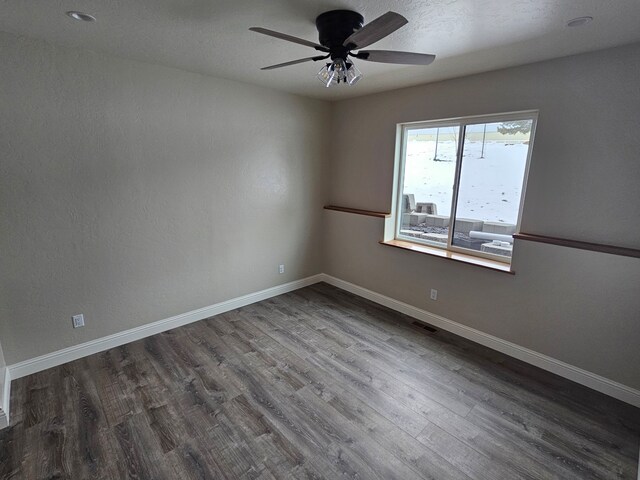 empty room with dark wood-type flooring and ceiling fan