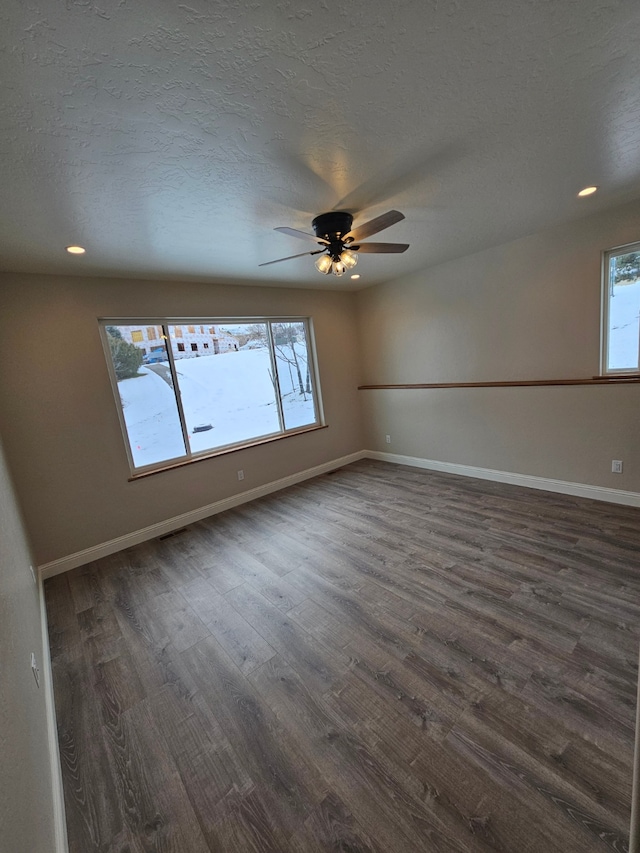 spare room featuring ceiling fan, dark hardwood / wood-style flooring, and a textured ceiling