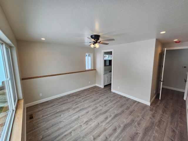 unfurnished room with ceiling fan, wood-type flooring, and a textured ceiling