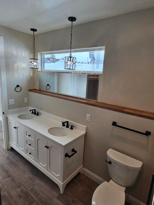 bathroom featuring vanity, hardwood / wood-style floors, a textured ceiling, and toilet