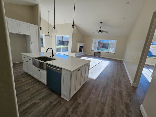 kitchen with sink, hanging light fixtures, an island with sink, white cabinets, and stainless steel dishwasher