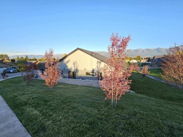 view of home's exterior with a mountain view and a yard