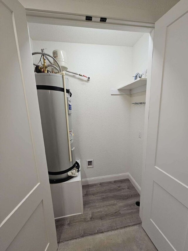 washroom featuring hardwood / wood-style flooring and water heater