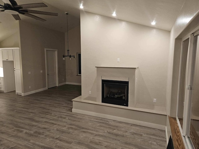 unfurnished living room with ceiling fan, wood-type flooring, and high vaulted ceiling