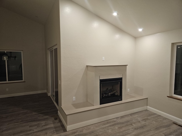 unfurnished living room with wood-type flooring and vaulted ceiling