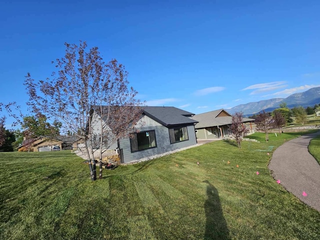 view of front of house featuring a mountain view and a front lawn