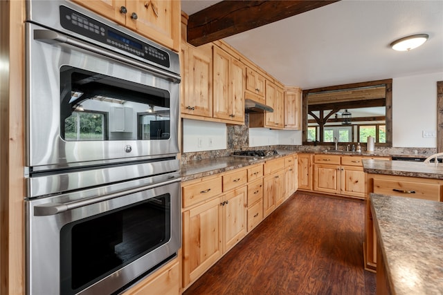 kitchen featuring appliances with stainless steel finishes, beam ceiling, dark hardwood / wood-style floors, and light brown cabinets