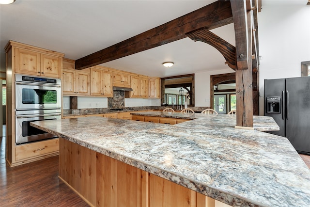 kitchen with light brown cabinets, refrigerator with ice dispenser, double oven, dark hardwood / wood-style floors, and beamed ceiling