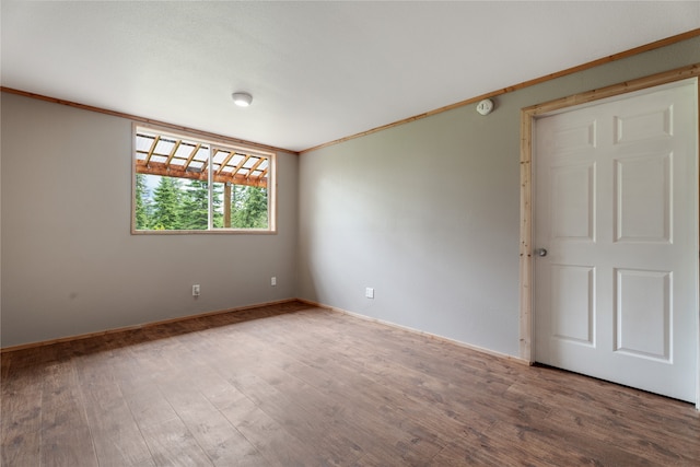 unfurnished room featuring hardwood / wood-style flooring and crown molding