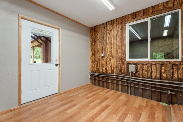 interior space featuring light wood-type flooring and wooden walls