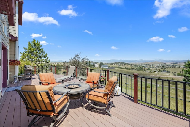 deck featuring a mountain view and an outdoor fire pit