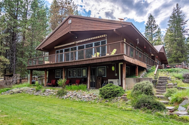 rear view of property featuring a deck and a lawn