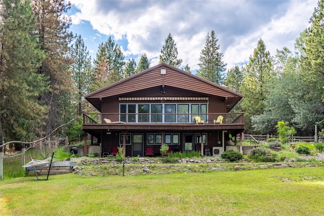 back of property featuring a lawn, a wooden deck, and fence