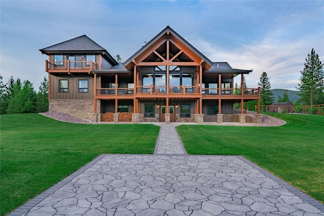 back of property featuring a lawn, a balcony, and a patio