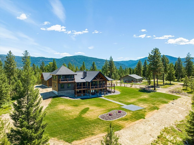 rear view of house featuring a mountain view and a yard