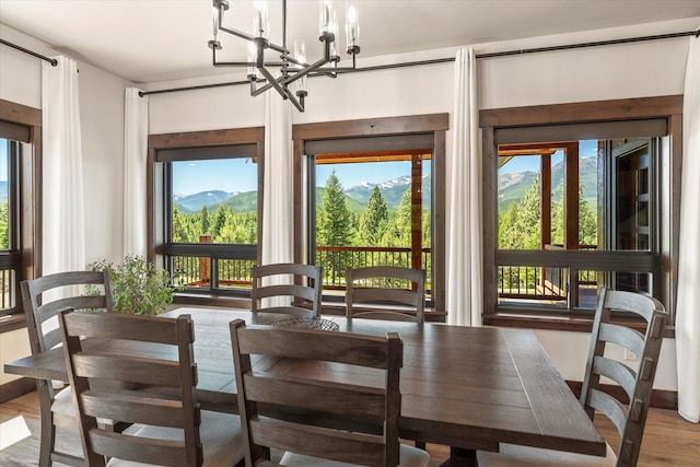 sunroom / solarium featuring a mountain view and a notable chandelier