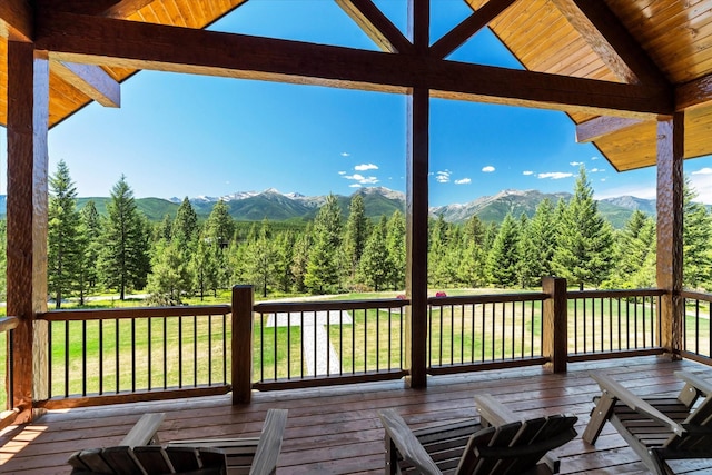 wooden terrace featuring a mountain view and a yard