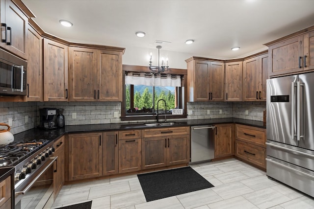 kitchen with decorative backsplash, sink, dark stone counters, and high end appliances