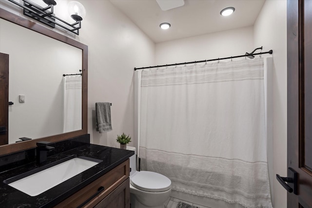 bathroom featuring toilet, vanity, and a shower with shower curtain