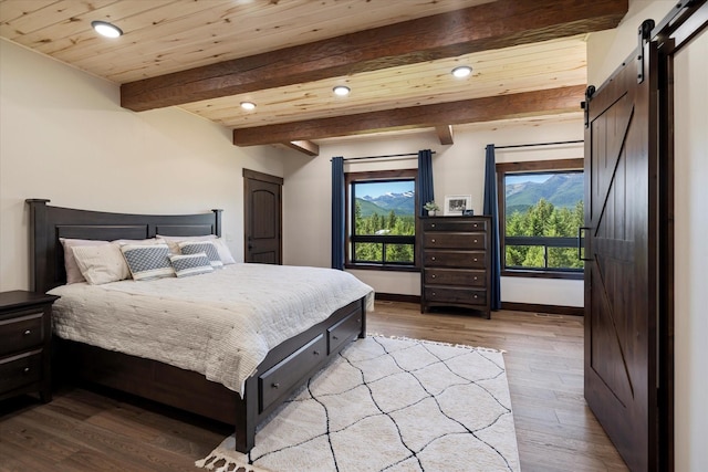 bedroom featuring wood ceiling, beam ceiling, a barn door, and light wood-type flooring