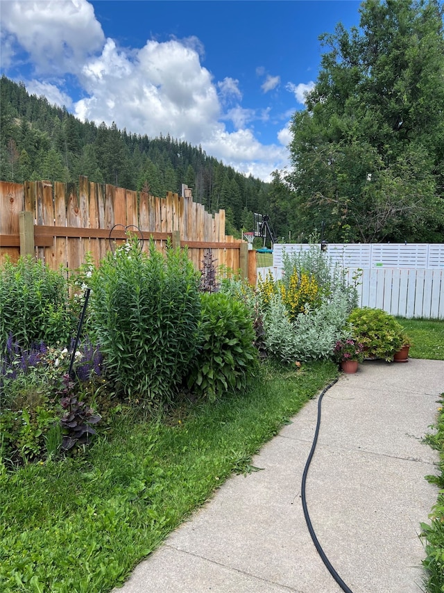 view of yard featuring fence and a view of trees