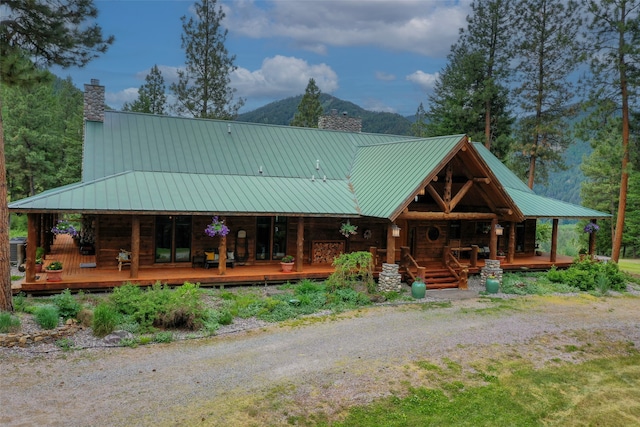 view of front facade with a mountain view, central AC unit, and covered porch