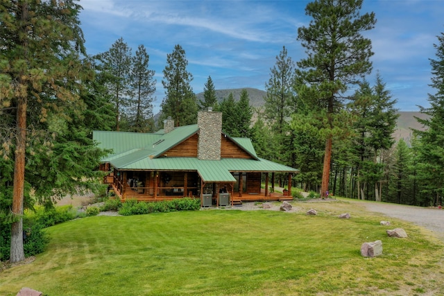 rear view of house featuring a lawn, a mountain view, cooling unit, and covered porch