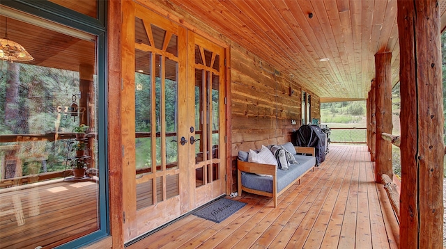 wooden terrace with a grill, french doors, and covered porch