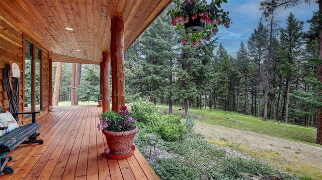 deck featuring covered porch and a yard