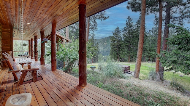 wooden terrace featuring a mountain view and a porch