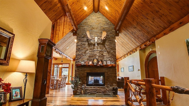 living room with wood ceiling, beam ceiling, wood-type flooring, high vaulted ceiling, and a fireplace