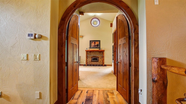 hallway featuring light hardwood / wood-style floors and vaulted ceiling