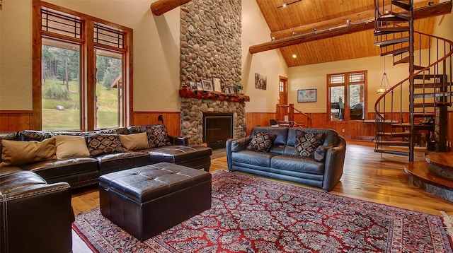 living room with beamed ceiling, high vaulted ceiling, hardwood / wood-style floors, a fireplace, and wood ceiling