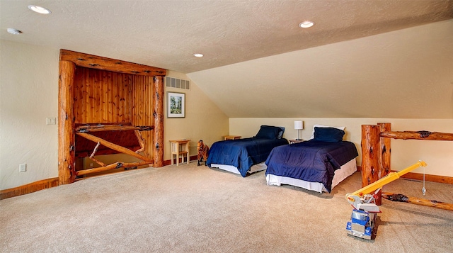 carpeted bedroom with vaulted ceiling and a textured ceiling