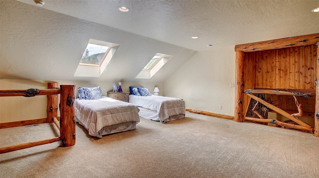 carpeted bedroom featuring vaulted ceiling with skylight and a textured ceiling