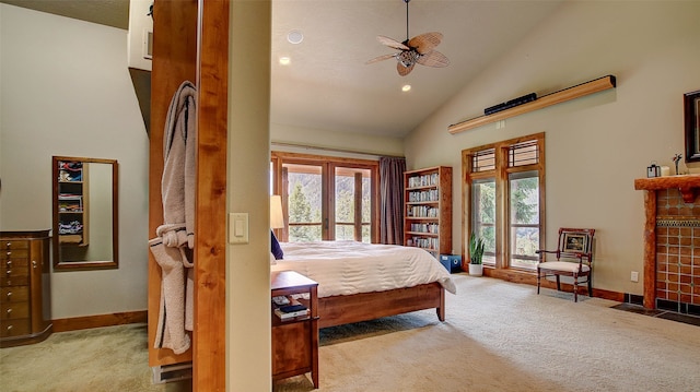 carpeted bedroom with access to outside, a tile fireplace, ceiling fan, and high vaulted ceiling